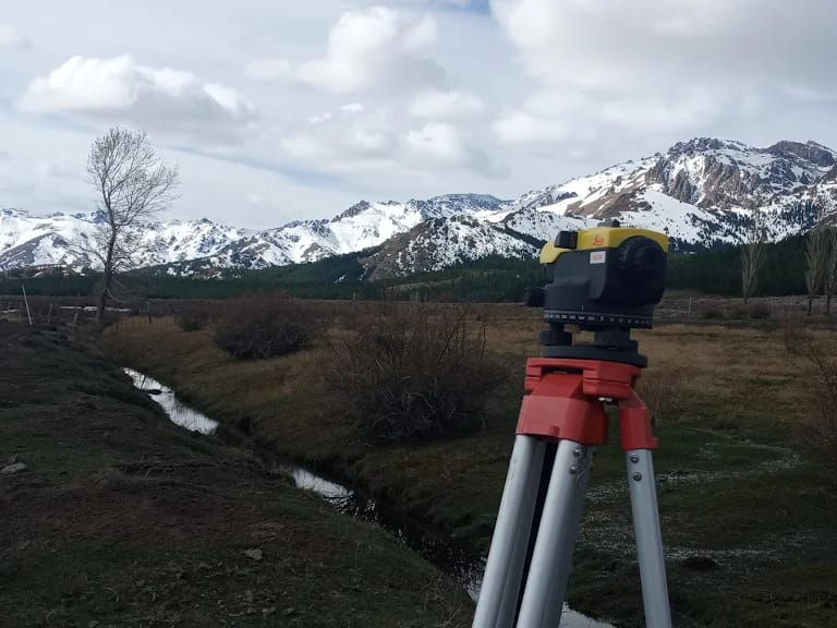 Nivel óptico con vista a montañas nevadas